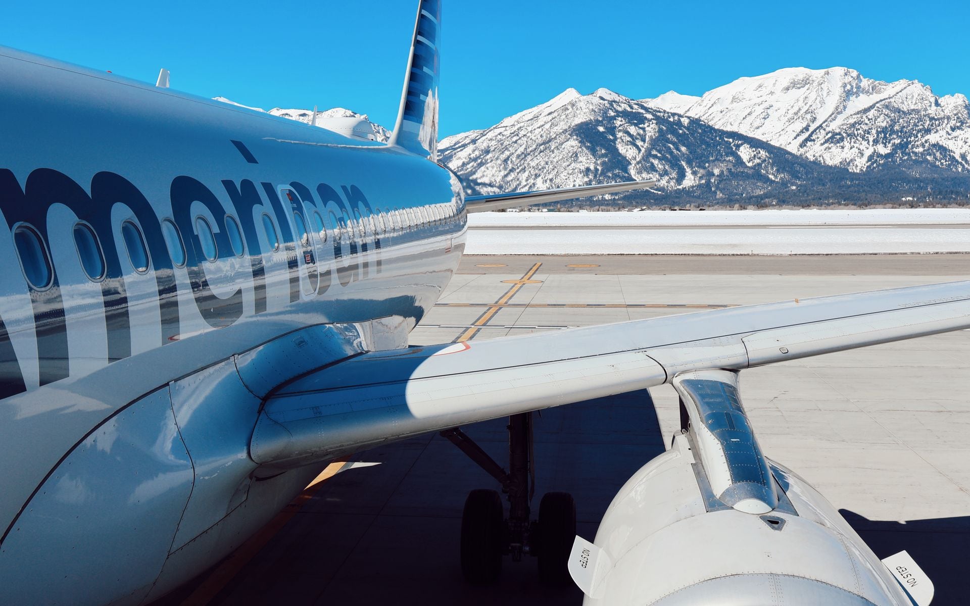 Small regional jets parked at Jackson Hole Airport with the Teton Range visible in the background, Wyoming