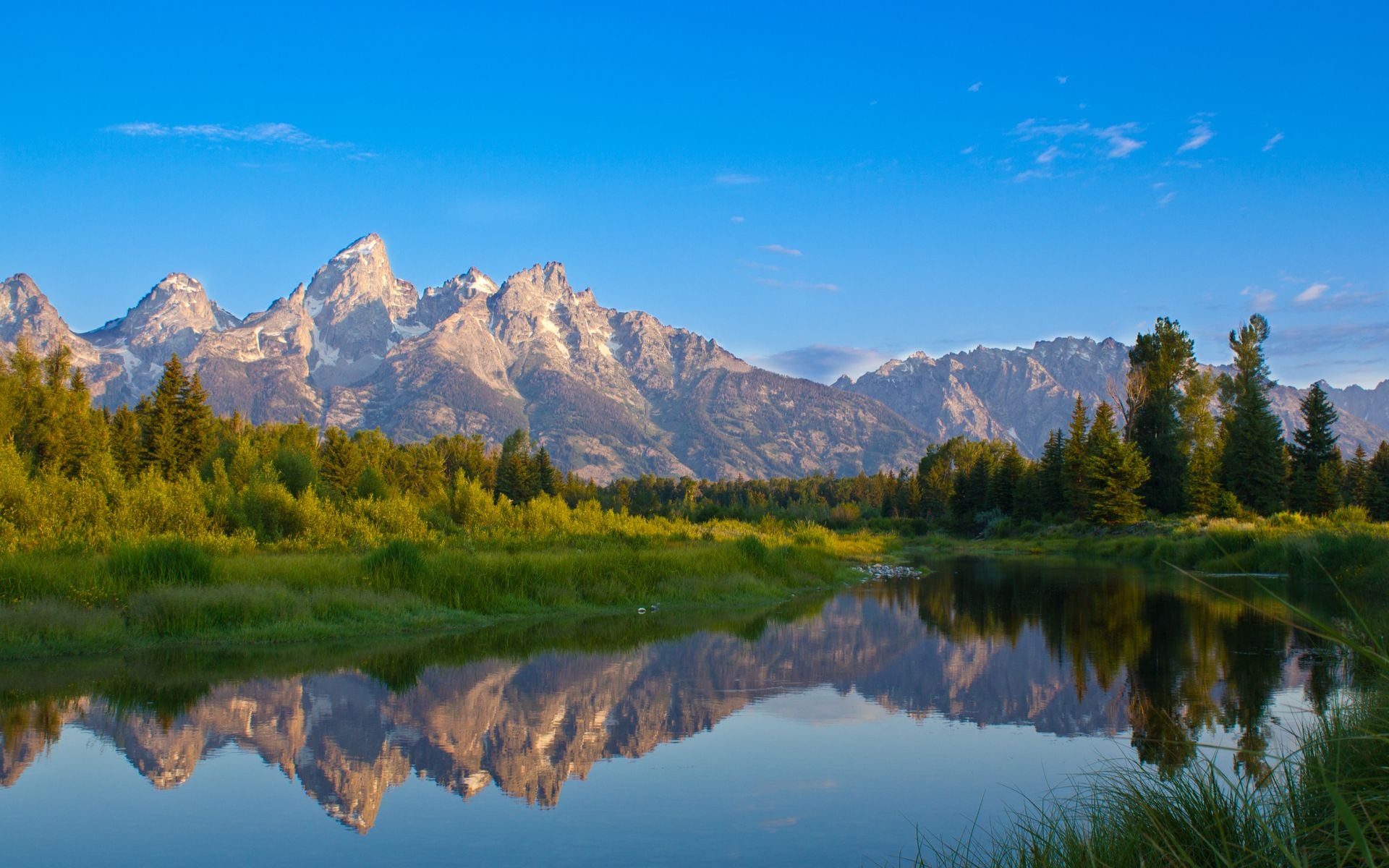 The Teton Range and its reflection in the Snake River on a clear summer morning in Grand Teton National Park, Wyoming